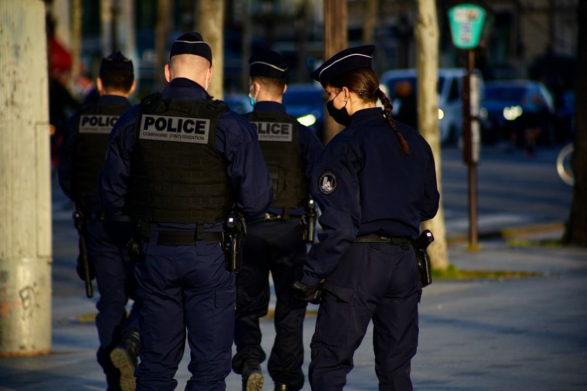 Uniformed police officers walking a city street at dusk