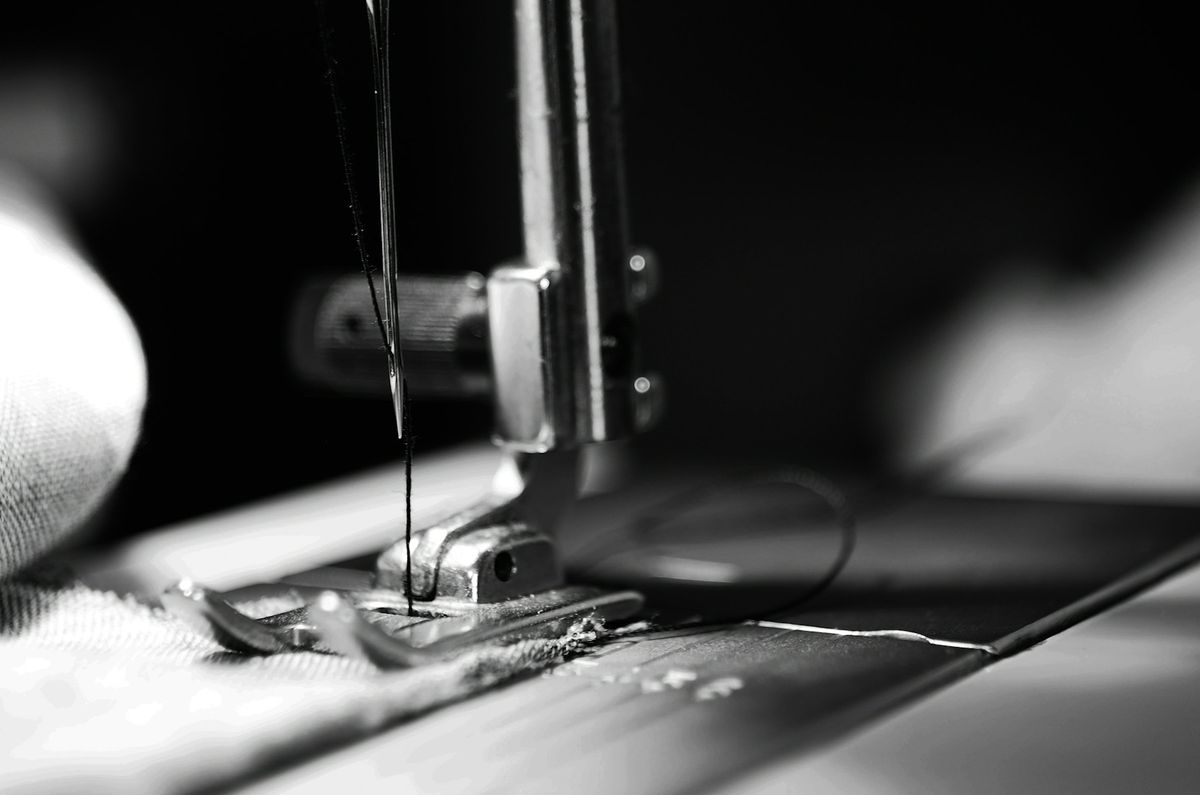 Close-up of a sewing machine needle stitching fabric